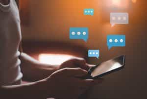 Person using a smartphone with digital chat icons, representing emergency communication apps during network outages
