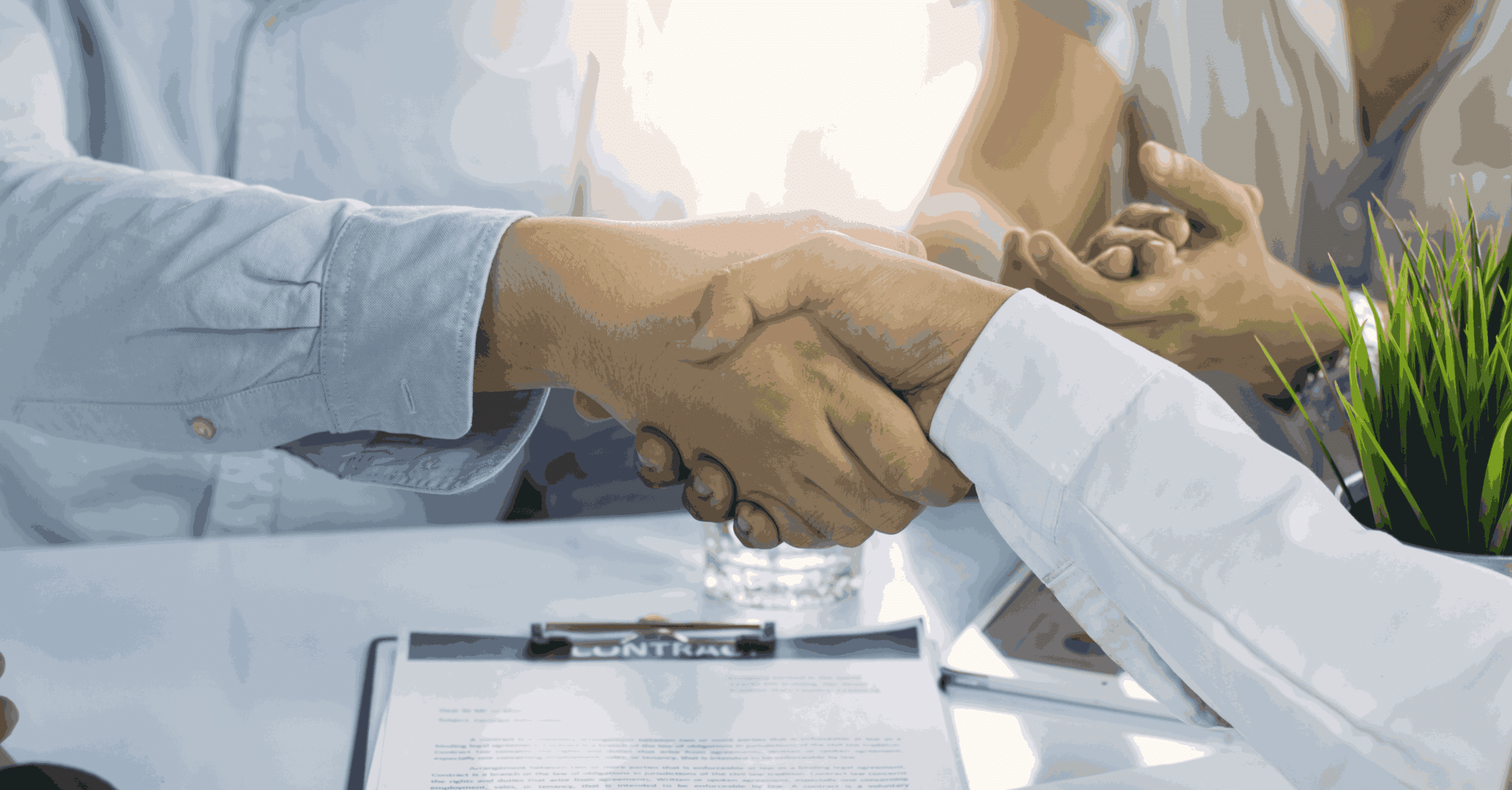 Two business professionals shaking hands over a signed contract, symbolizing a successful business agreement and partnership.
