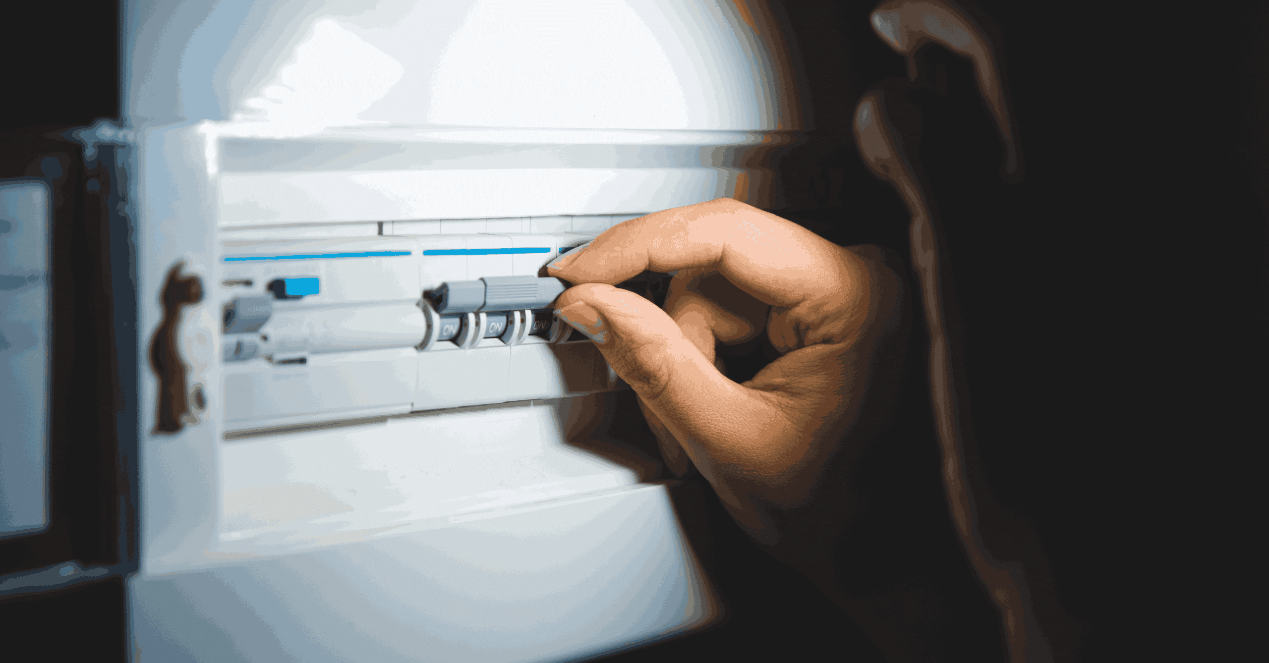 Hand switching on circuit breakers in a home electrical panel for power control and electrical safety.